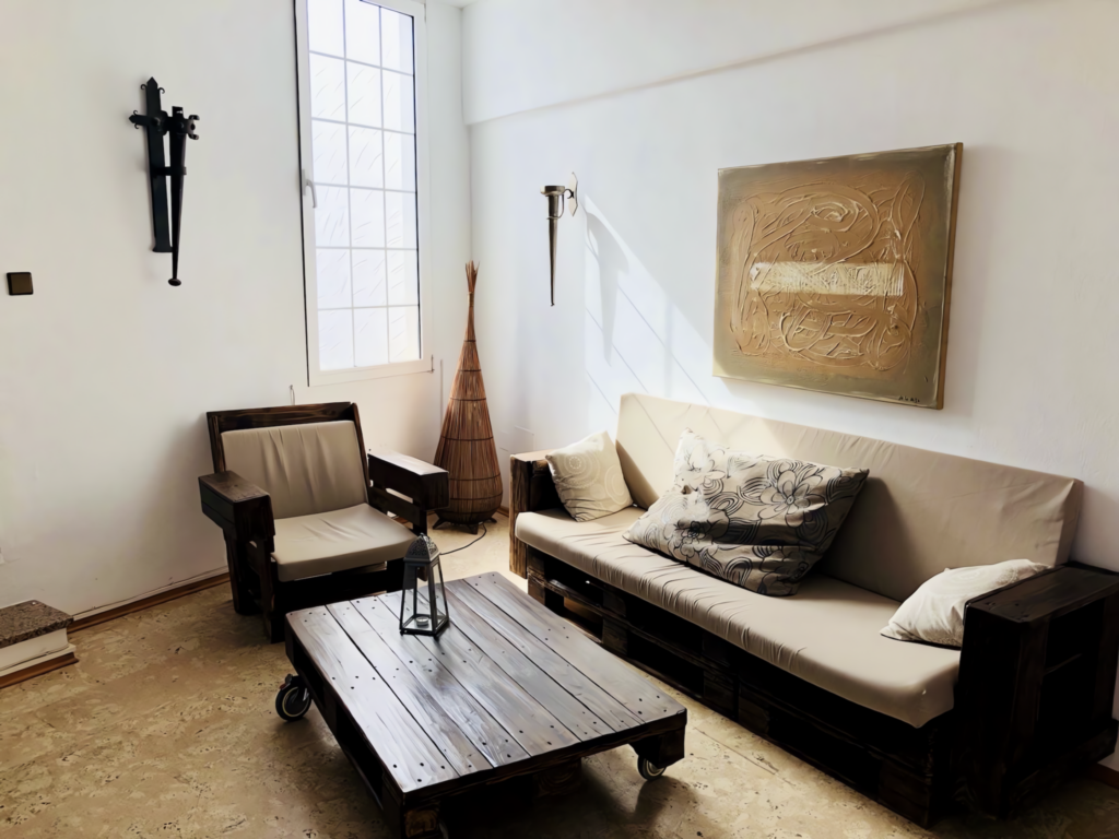 Ein Wohnzimmer mit einem Sofa und einem Couchtisch aus Holz sowie einem Kunstwerk an der Wand.