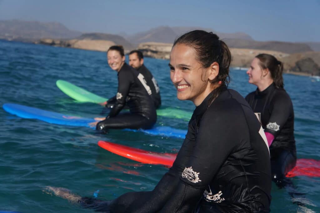 Gruppe von Surfern mit Boards im Wasser vor La Pared, Fuerteventura
