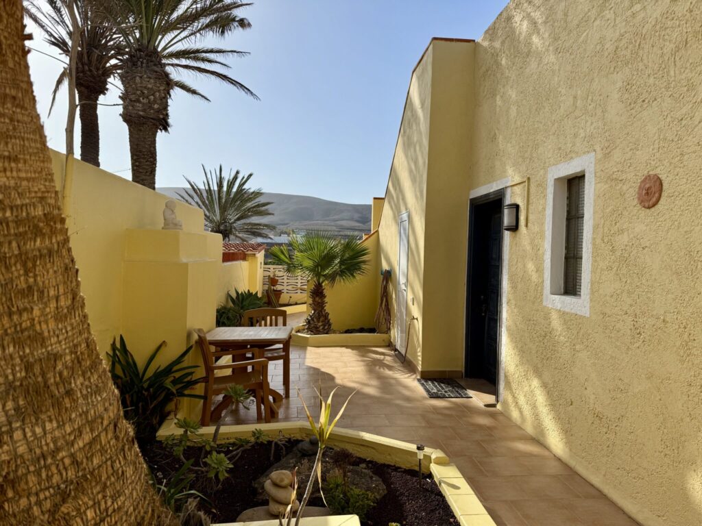 Gelbes Apartment mit Terrasse, Palmen und Pflanzen in Fuerteventura.