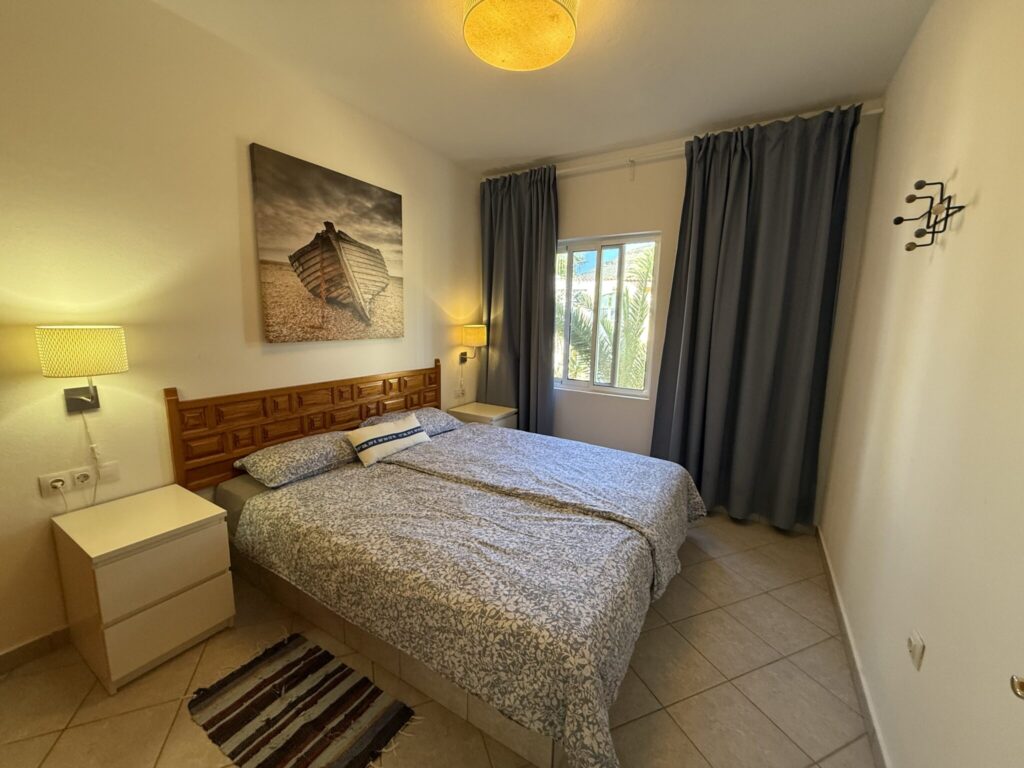Schlafzimmer mit Doppelbett und Kunstwerk an der Wand Schlafzimmer mit einem Doppelbett, Nachttischen und einem Kunstwerk über dem Bett.