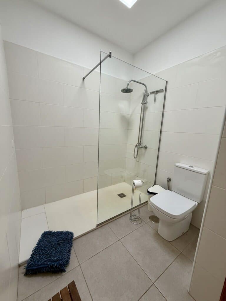 Modernes Badezimmer mit einer Glasdusche und einem WC in neutralen Farben.