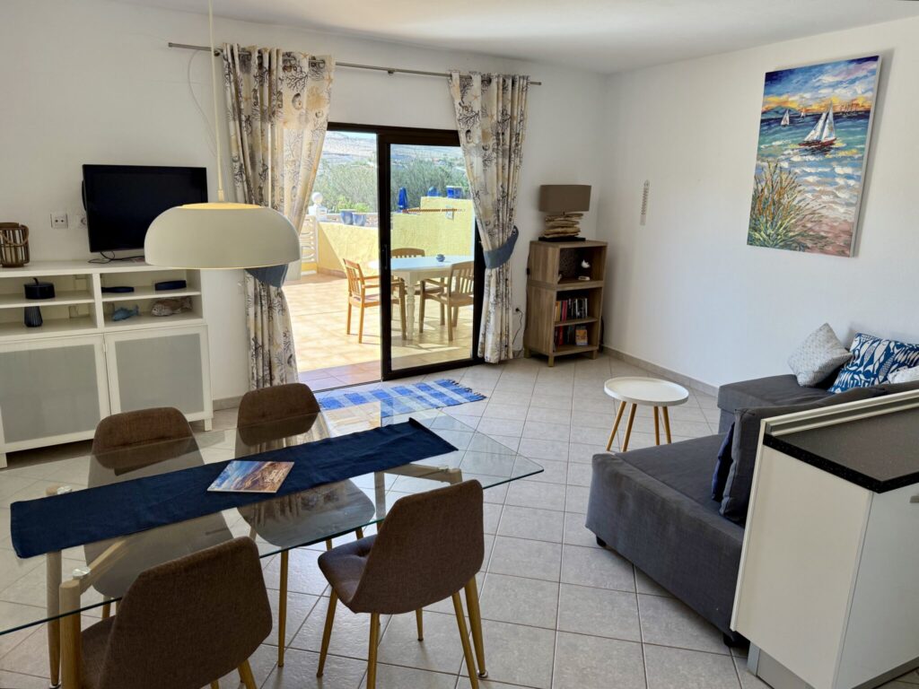 Wohnzimmer mit Esstisch und Sofa Ein Wohnzimmer mit einem Esstisch, einem Sofa und einem Gemälde an der Wand.