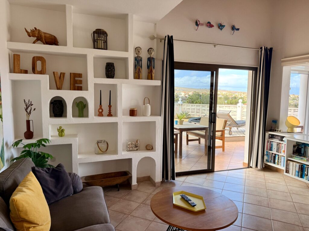 Wohnzimmer mit Regalelementen und Ausblick Wohnzimmer mit einem Sofa, einem Couchtisch und einem Regal mit Dekorationsobjekten.