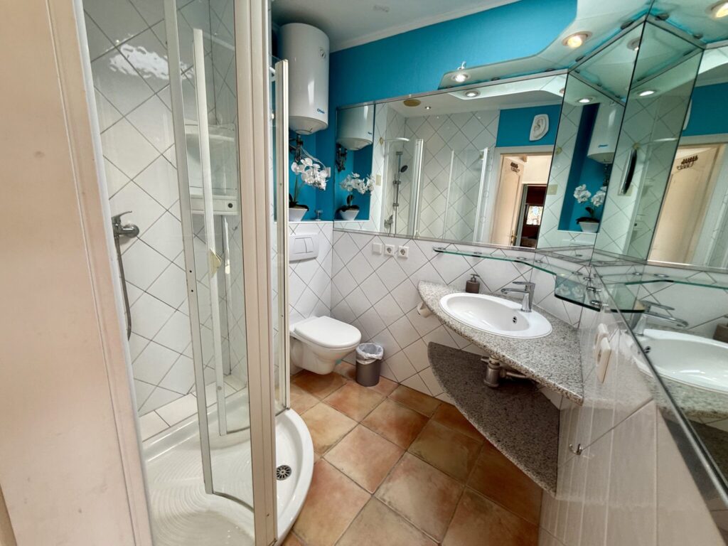 Badezimmer mit Dusche, Waschbecken und Toilette in einem modernen Design.