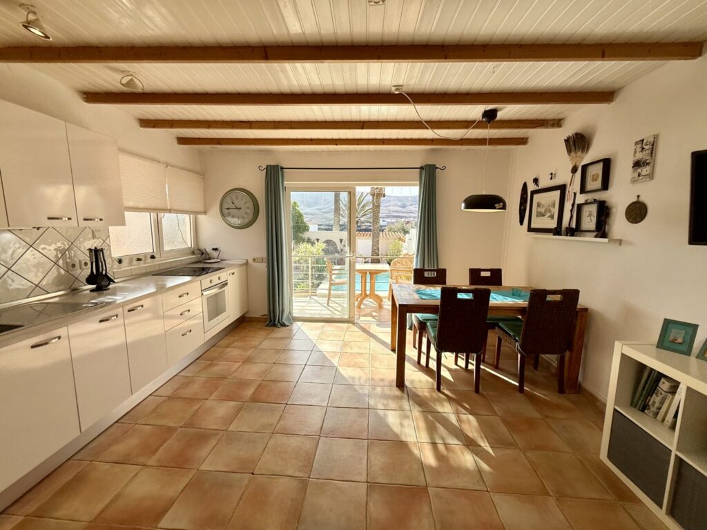 Küche mit Essbereich in einem Apartment, ausgestattet mit Tisch und Stühlen.