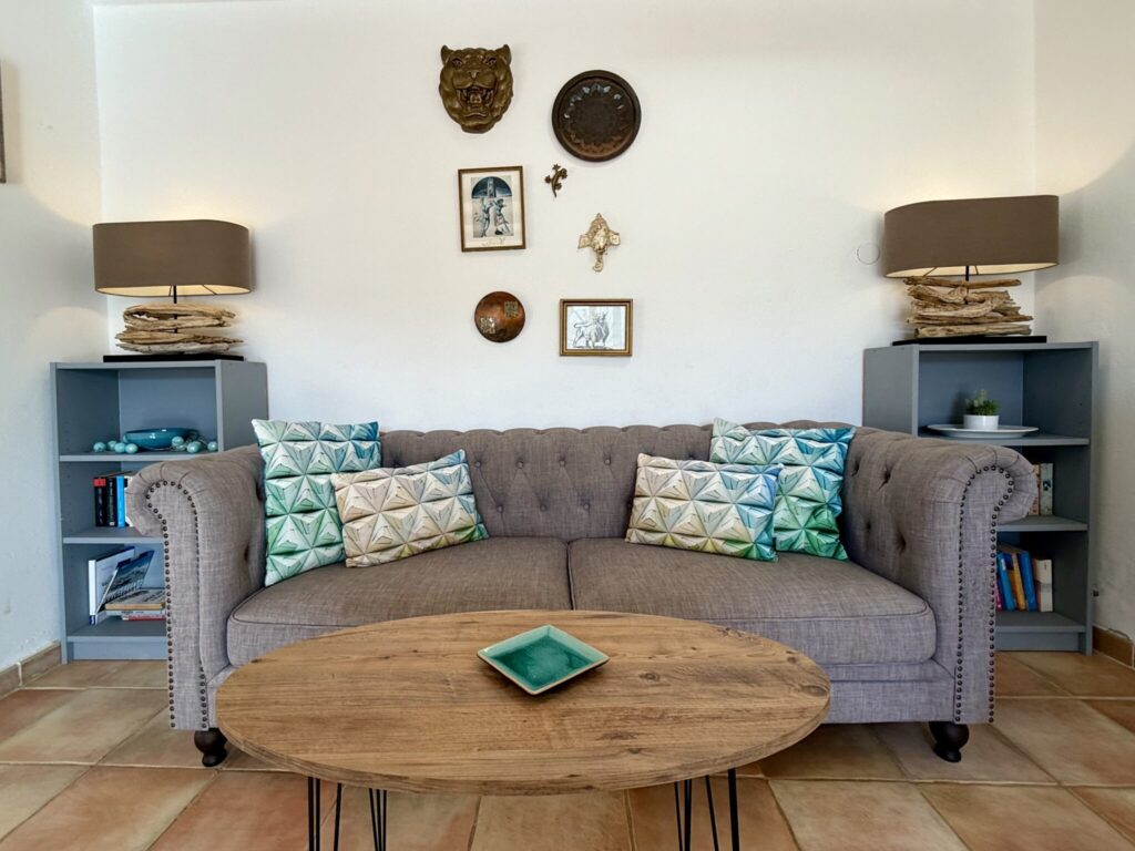Wohnzimmer mit Sofa und Dekoration Grau gepolstertes Sofa mit bunten Kissen und einem Couchtisch im Wohnzimmer.