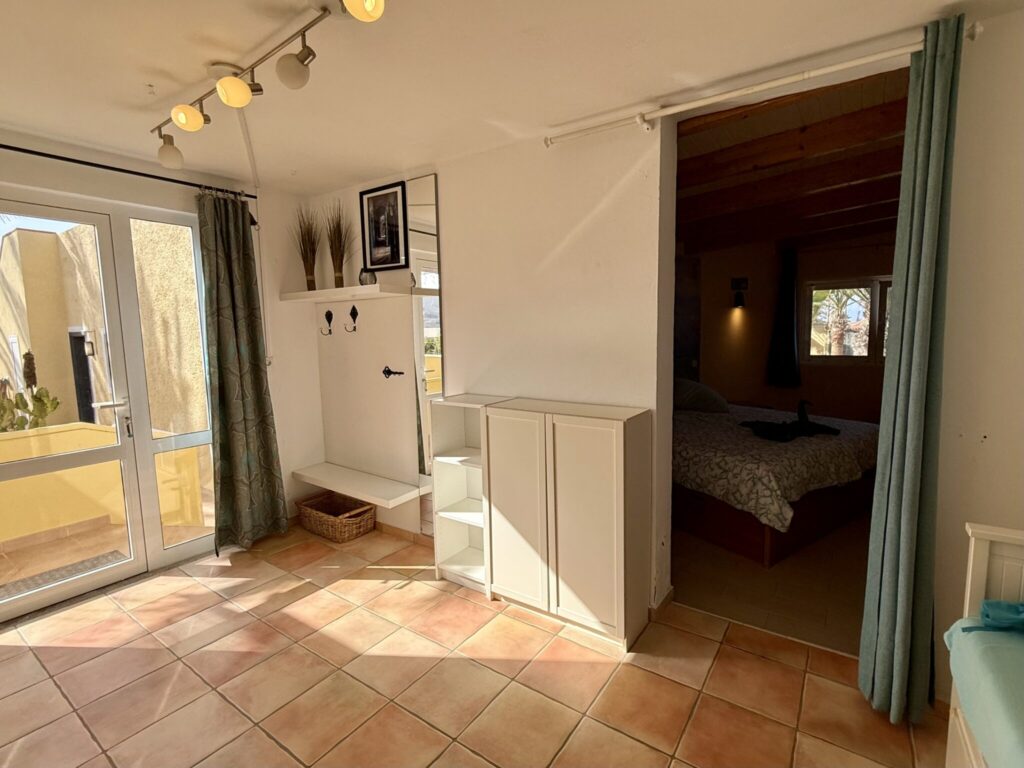 Innenansicht eines Apartments mit einem Wohnbereich und einem angrenzenden Schlafzimmer.