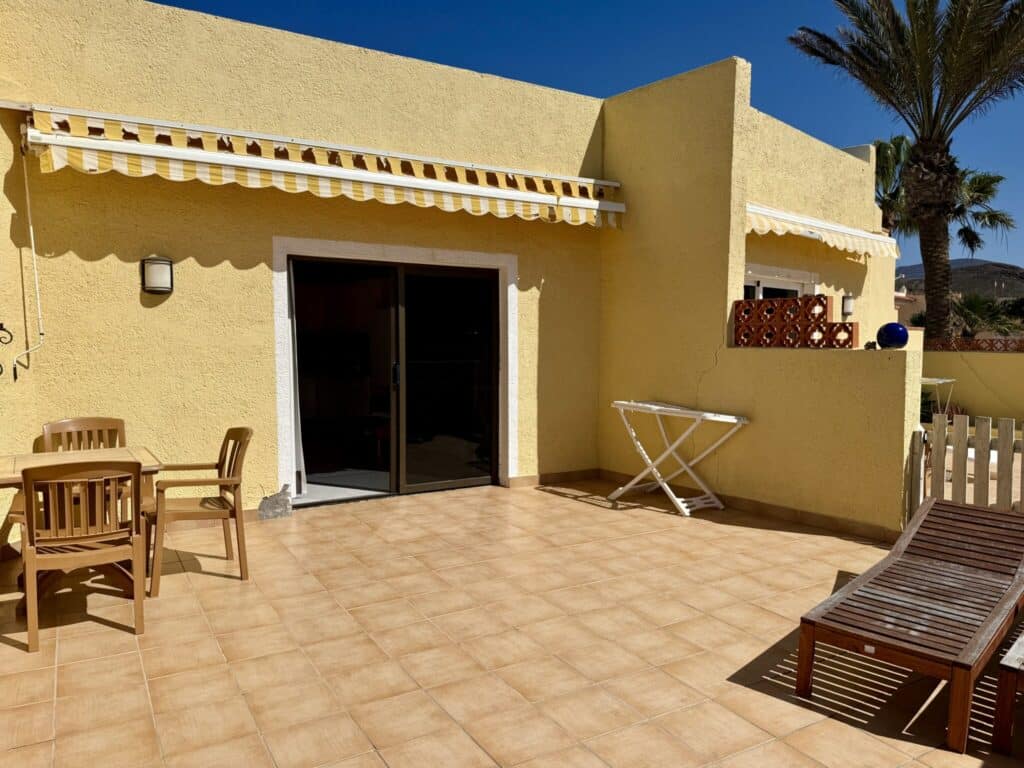 Gelbe Wand mit Markise und Terrassenmöbeln in einem Apartment in La Pared, Fuerteventura.