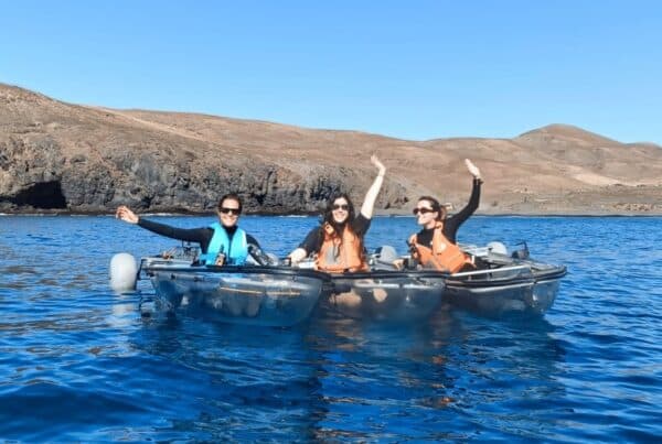 Kleine Gruppe in transparenten E-Kajaks im türkisen Wasser vor Tarajalejo, Fuerteventura