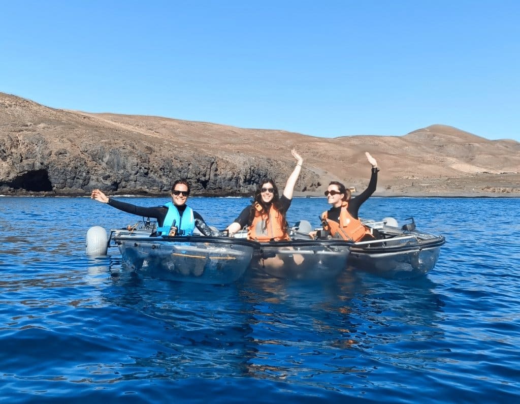 Kleine Gruppe in transparenten E-Kajaks im türkisen Wasser vor Tarajalejo, Fuerteventura